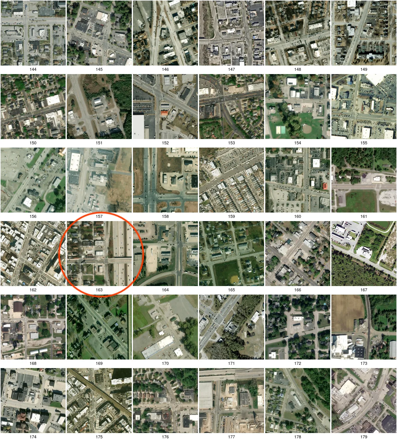 A contact sheet of 36 satellite tiles of bp candidates; tile 163 is boxed in red: a canopy between a strip mall and a wide expressway, with a road bridge crossing the expressway